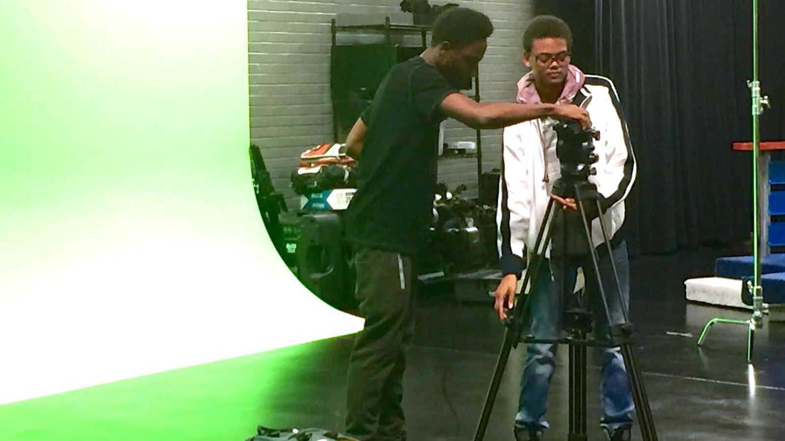 Davoni White (left) and Chris Patterson (right) rush to set up a camera in one minute during an advanced studio production class at Warren Central High School. The FrontRunner studio (pictured here) was funded by the Race to the Top grant.