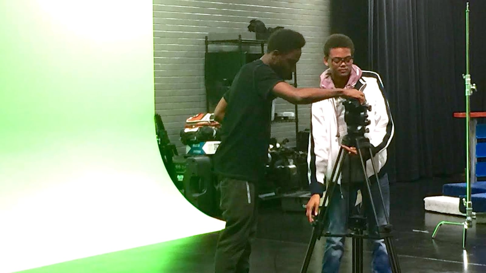 Davoni White (left) and Chris Patterson (right) rush to set up a camera in one minute during an advanced studio production class at Warren Central High School. The FrontRunner studio (pictured here) was funded by the Race to the Top grant.