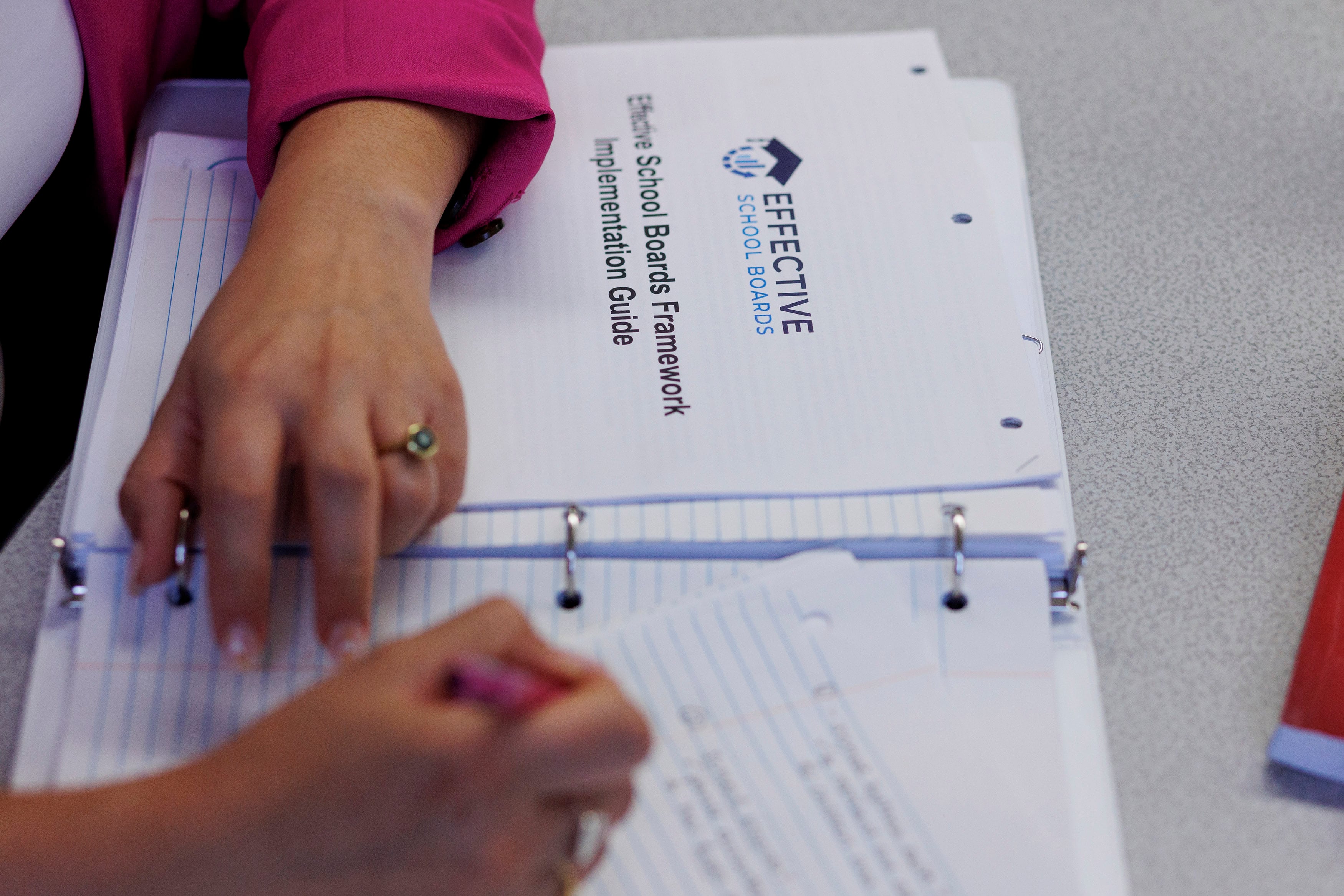 A bird's eye view of a pair of hands taking notes.