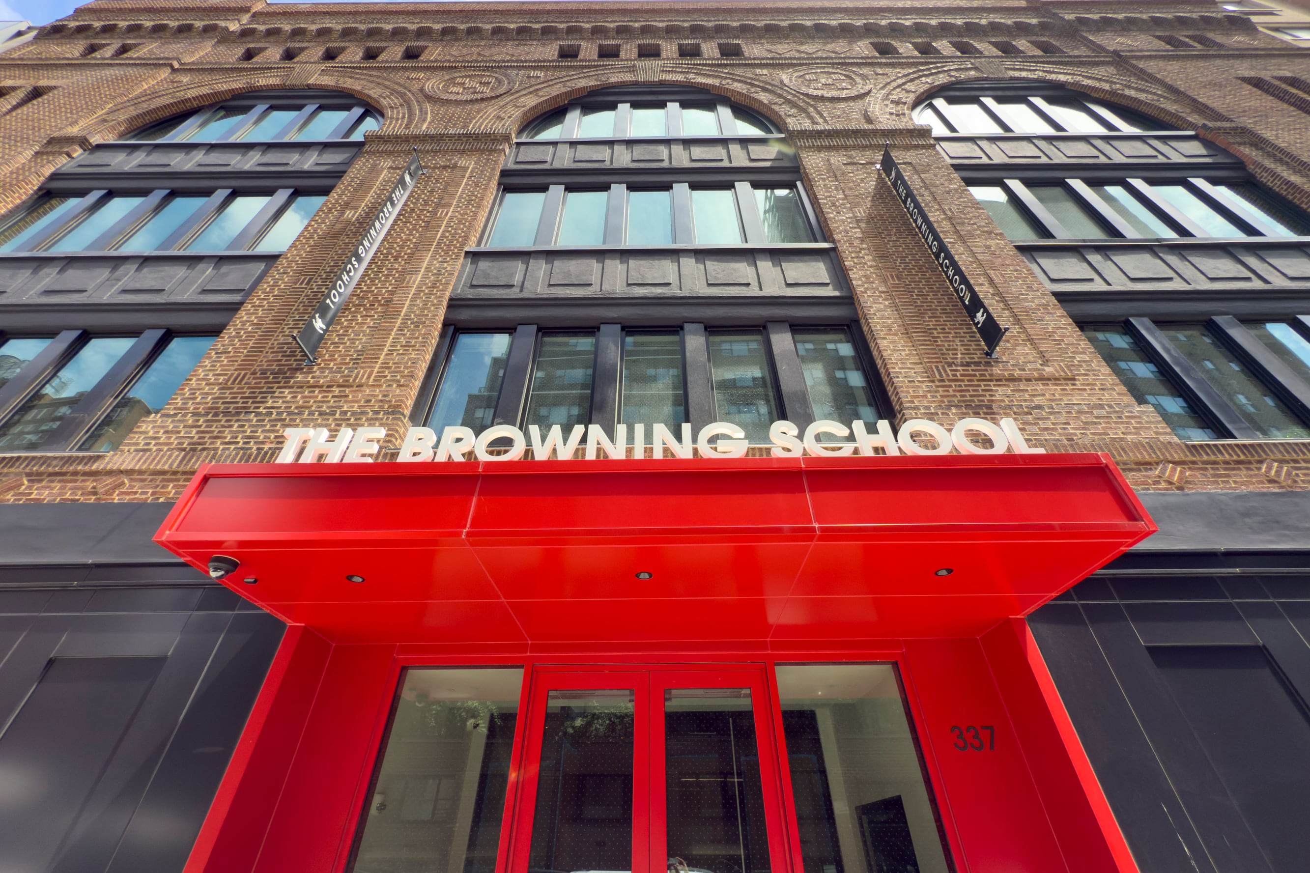 A photograph of a brown stone building with a red front.