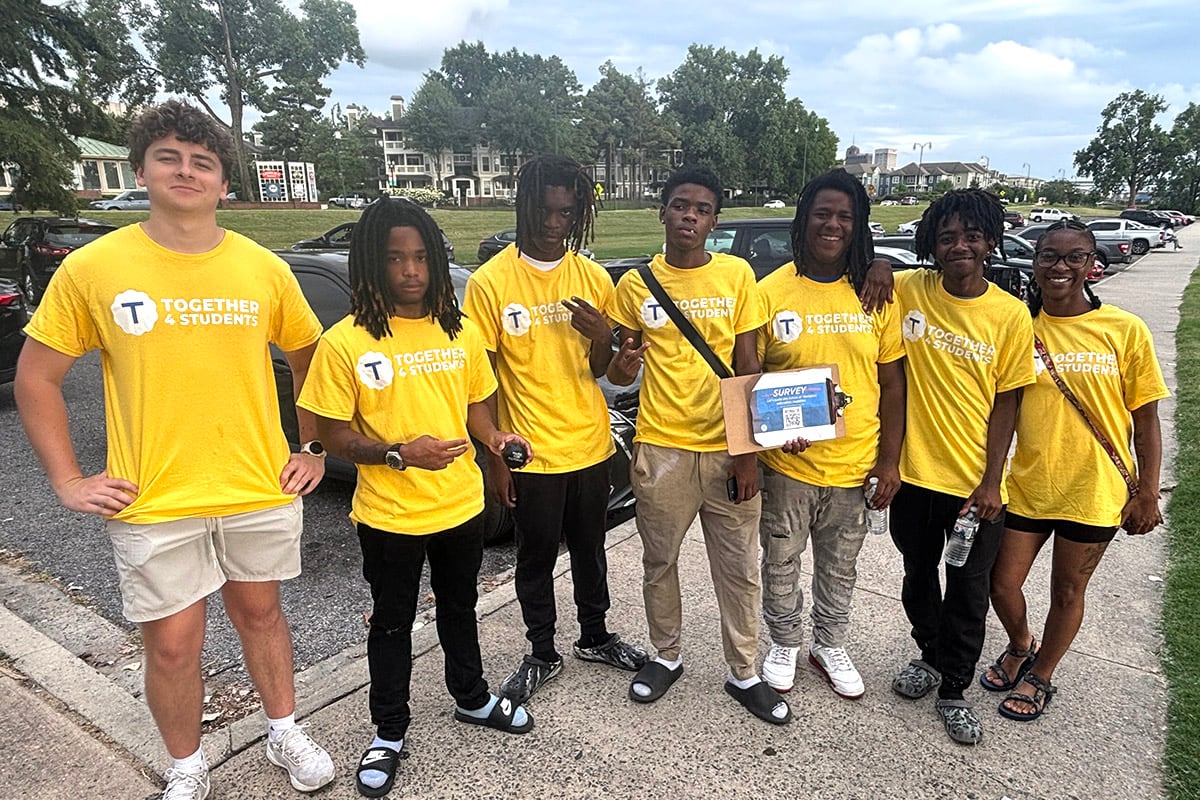 Seven people pose in yellow t-shirts.
