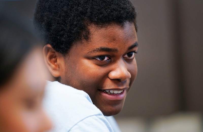 A Black male is smiling.