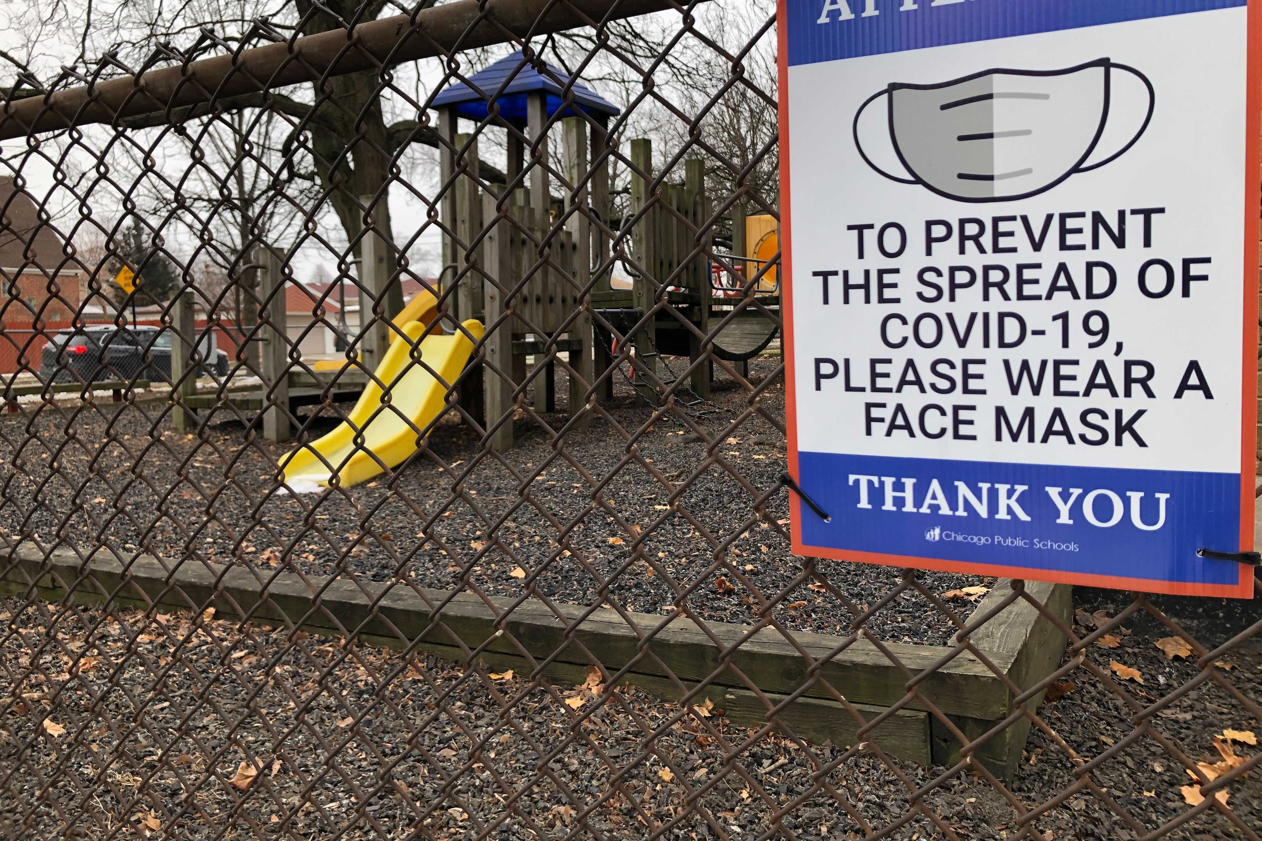 A closed Chicago school playground has a sign for wearing face masks due to COVID-19.