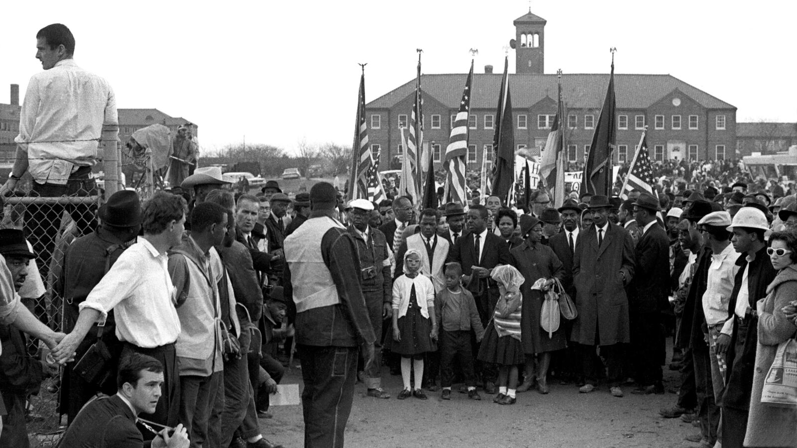 In this black and white image from 1965, John Lewis leads 25,000 marchers in front of City of St. Jude Church in Selma, Ala, who prepare to march to the capitol in Montgomery, Ala.