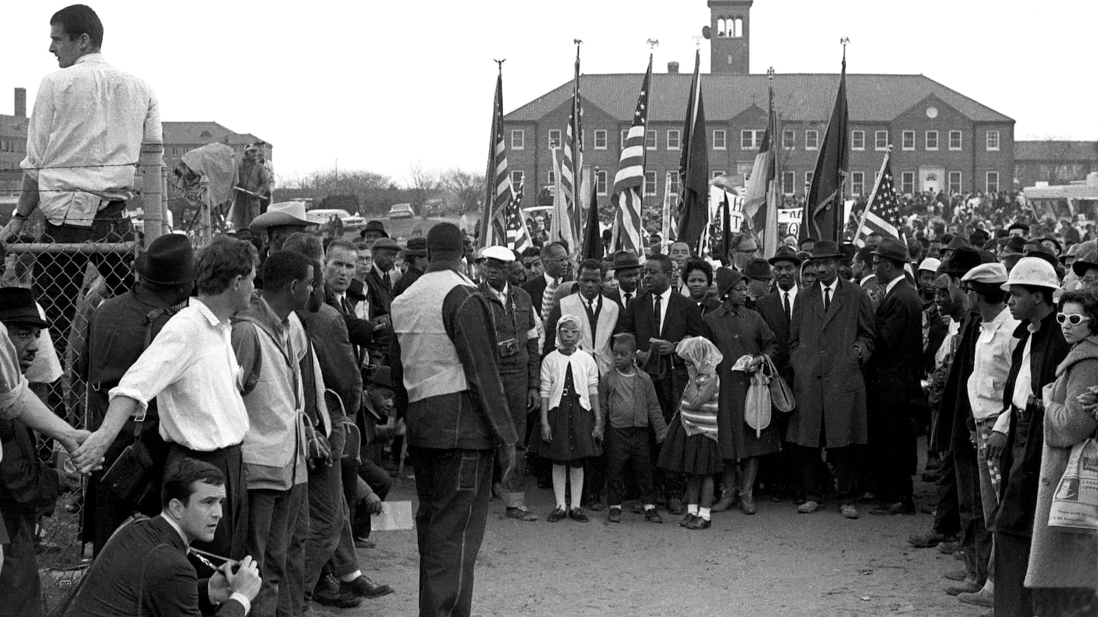 In this black and white image from 1965, John Lewis leads 25,000 marchers in front of City of St. Jude Church in Selma, Ala, who prepare to march to the capitol in Montgomery, Ala.