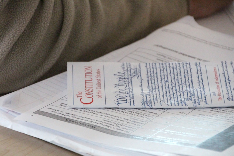 A paper copy of the U.S. Constitution sits on a worksheet on a student's desk.