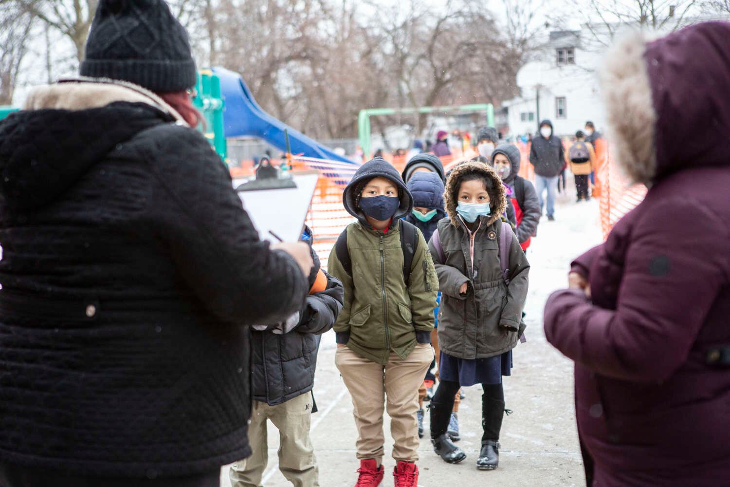 Students line up to enter school wearing masks
