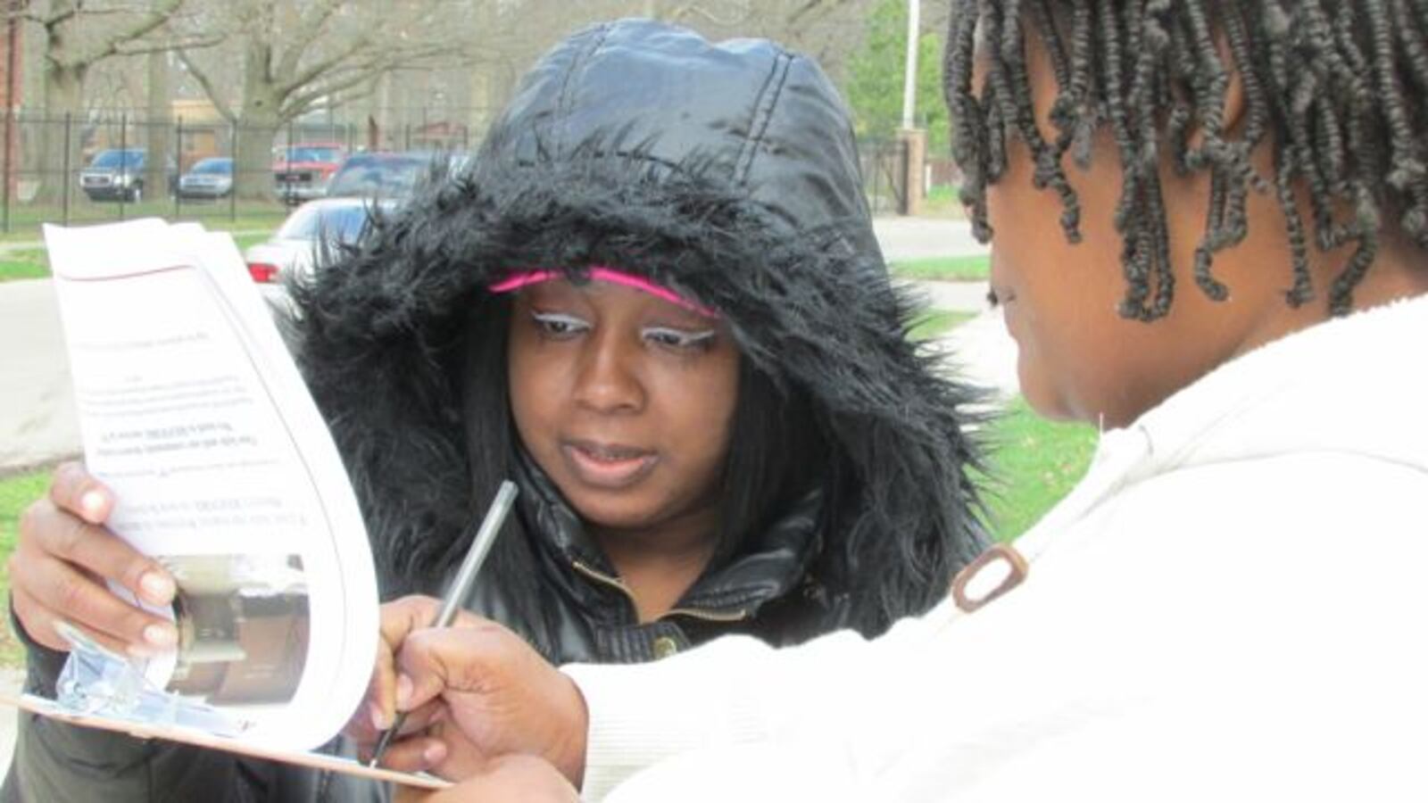 School 93 parent Lechess Taylor gets a parent to sign a petition to bring Project Restore to the school. (Scott Elliott)