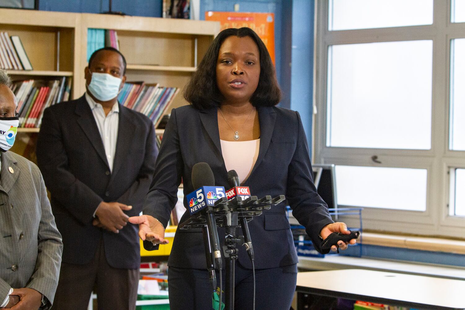 School chief Janice Jackson speaking into microphones at a press conference.