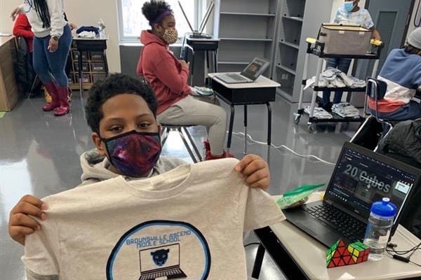 Seventh grader Jamari Adams proudly displays a shirt from the Brownsville Ascend Middle School.
