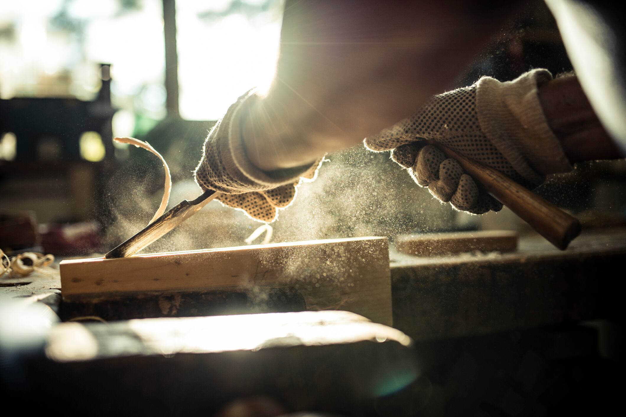A person carving wood in a carpentry workshop.