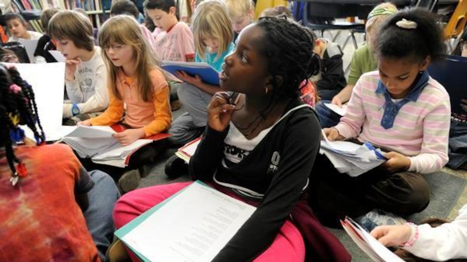 Anaelle Dahourou, 9, right, listens while her teacher, Anne Ertman, reads to the third- grade class at University Park Elementary School in Denver in 2010.