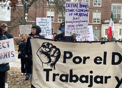 People hold signs at a rally.