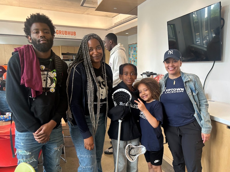 Three adults and two children stand next to each other posing for a photograph.