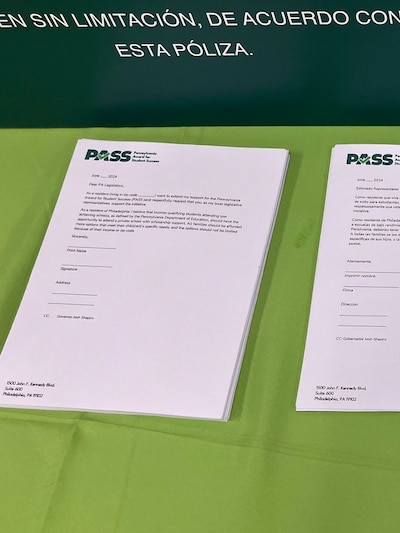 A white sheet of paper with black ink and sitting on a green table cloth.