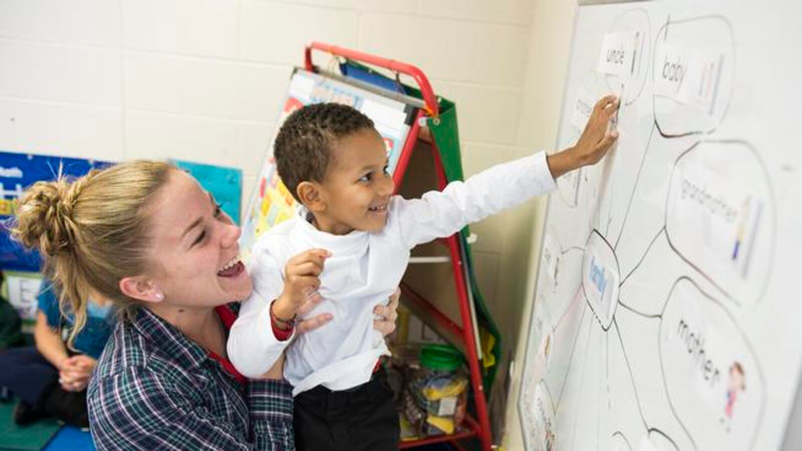 Izaiah Fofana, held up by his teacher, Lisa Monroe, learns about family members during class for 3- and 4-year-olds at Green Valley Elementary in 2014.