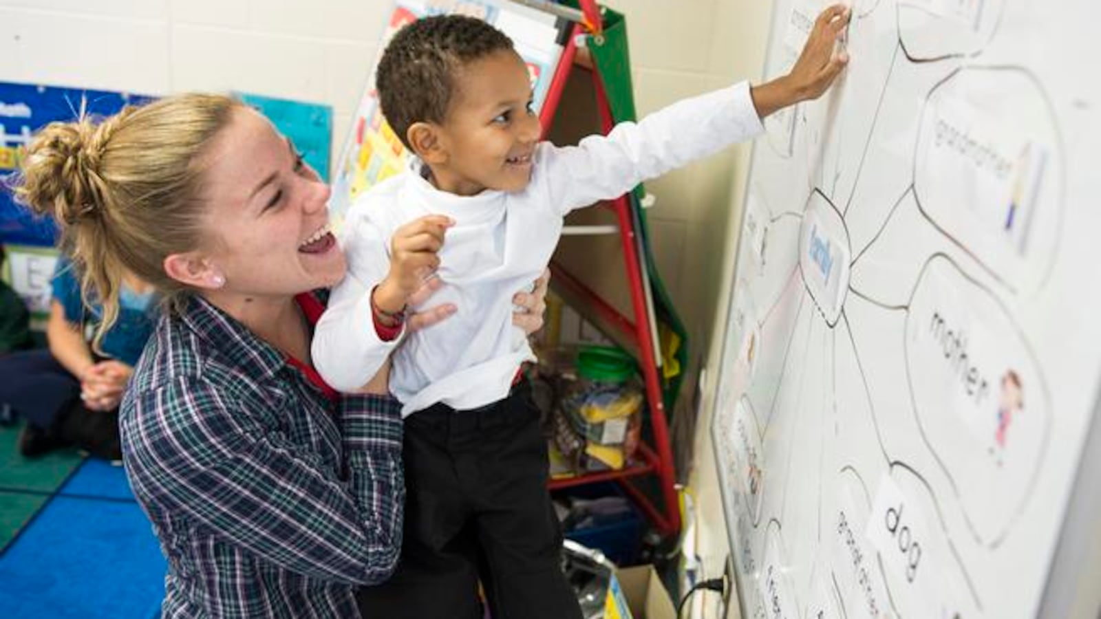 Izaiah Fofana, held up by his teacher, Lisa Monroe, learns about family members during class for 3- and 4-year-olds at Green Valley Elementary in 2014.
