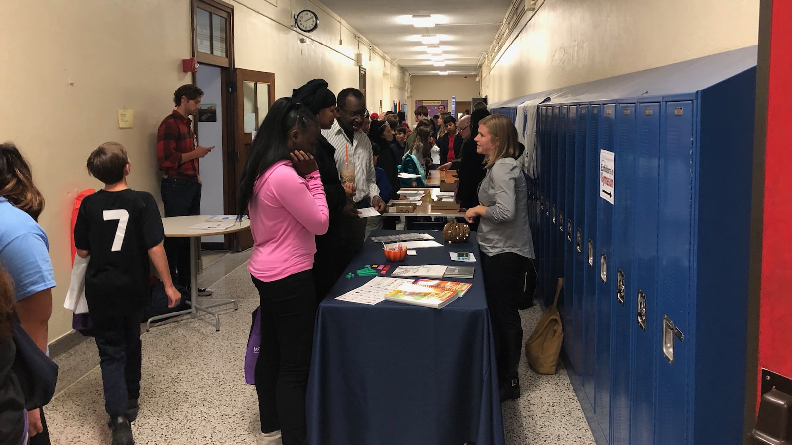 Students speak with school representatives in the hallway of Disney II Magnet High School during a high school admissions fair.