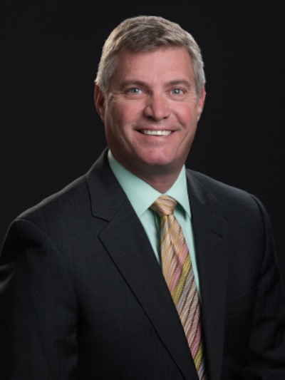 A headshot of a man wearing a suit and tie.