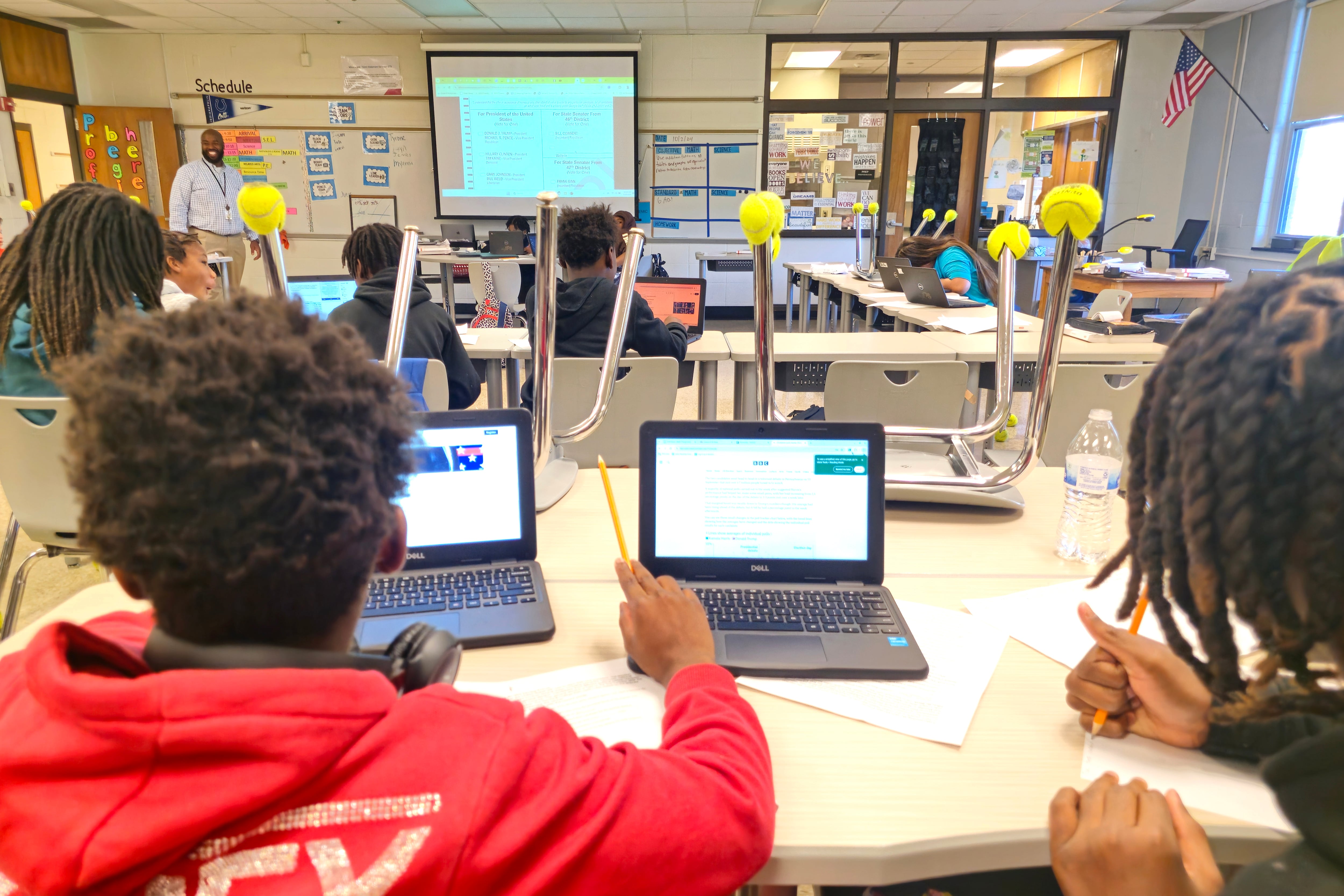 Students work from their desks on laptops in a classroom.