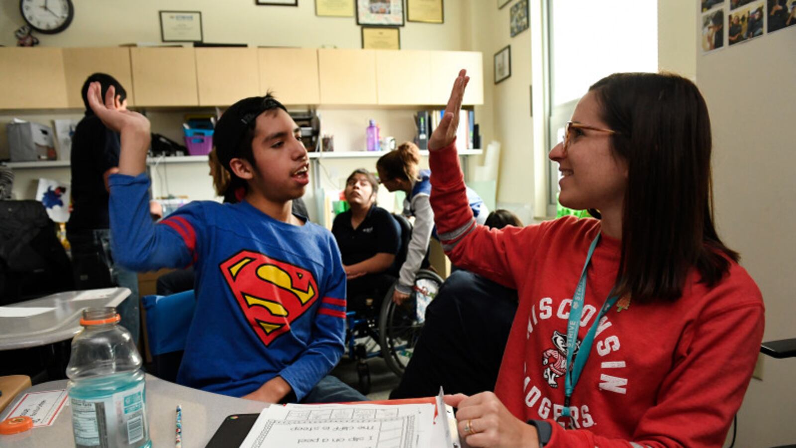 Josue Bonilla, 13, left, gets a high five from his teacher Wendi Sussman, right, after completing a hard reading lesson in his multi-intensive special education class at STRIVE Prep charter school in Denver in 2016.