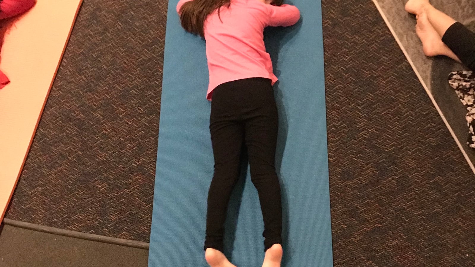 A girl rests at the end of yoga club at Doull Elementary in Denver.
