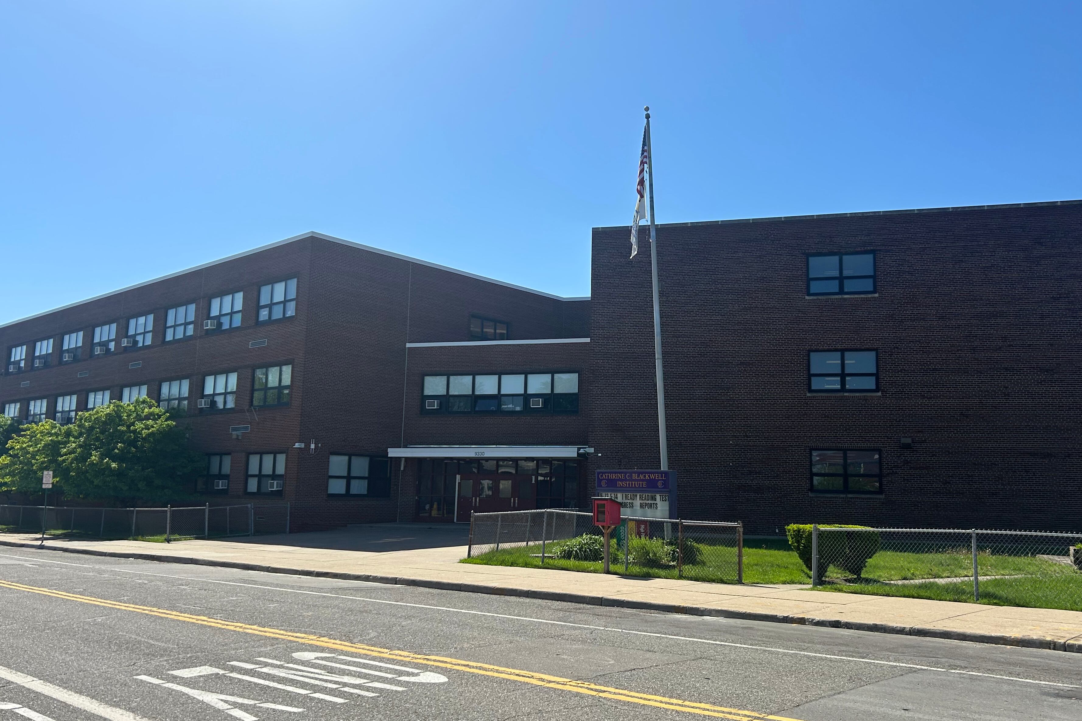 The exterior of a large brown brick school building.
