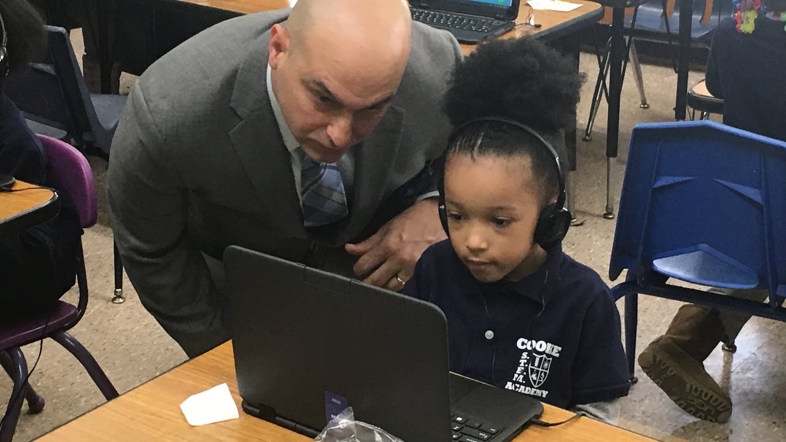 Superintendent Nikolai Vitti works with a student on a personal computer at Cooke STEM Academy.