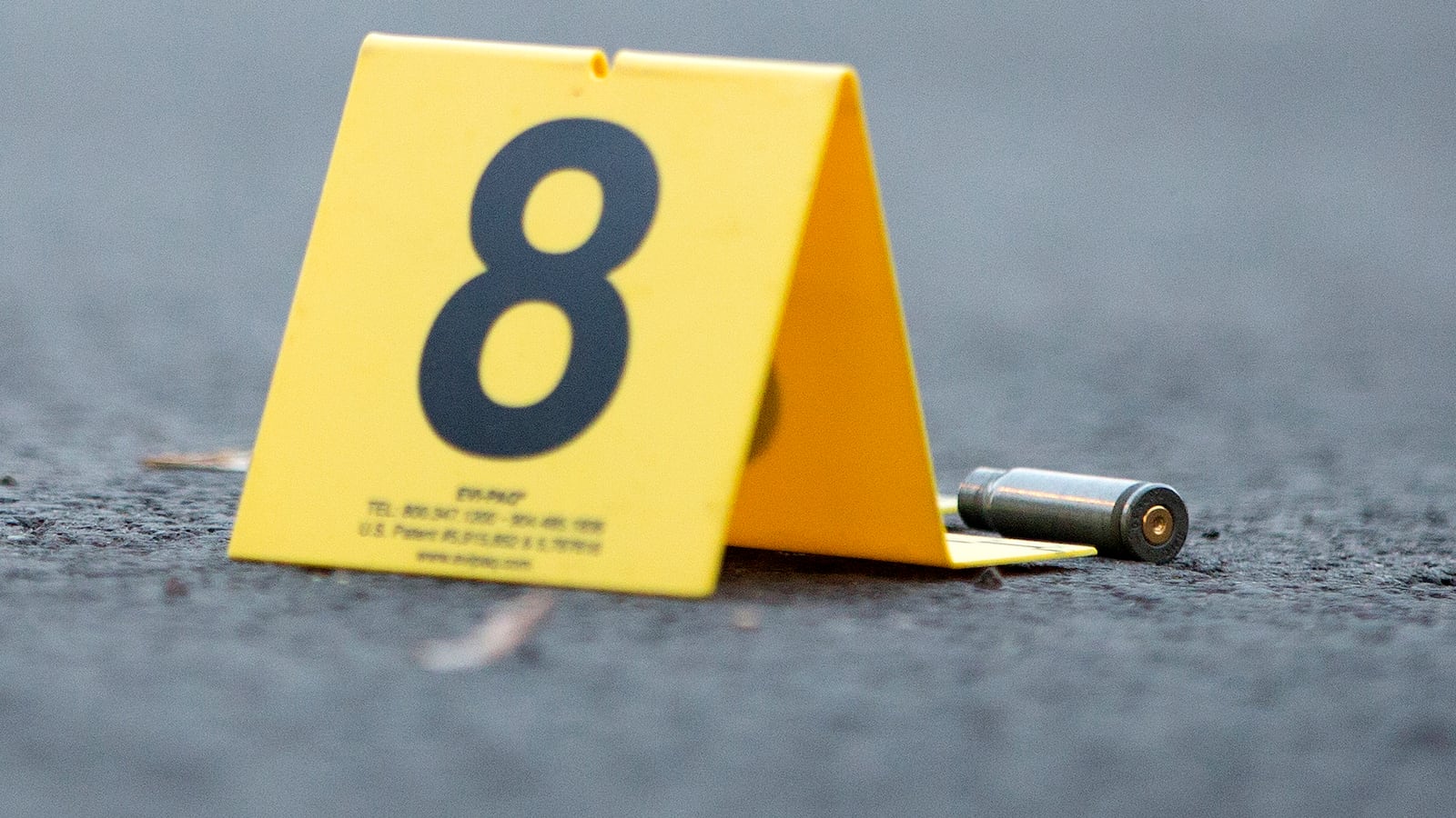 An evidence marker sits next to a rifle casing at the scene of a fatal shooting in the Back of the Yards neighborhood of Chicago in September 2016.