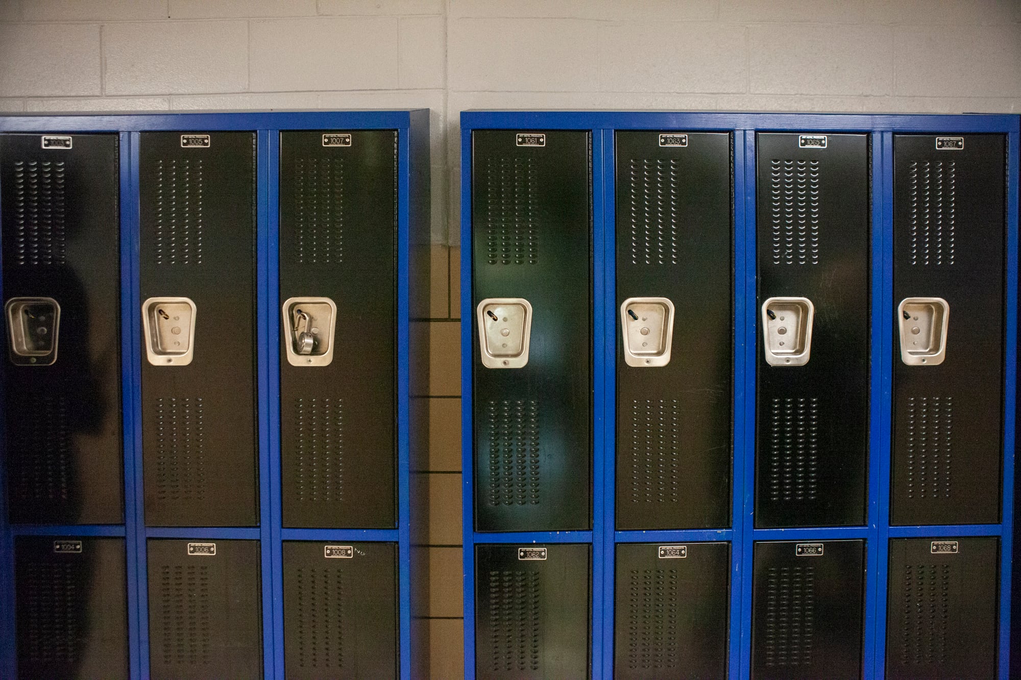 Black and blue lockers in a school hallway.