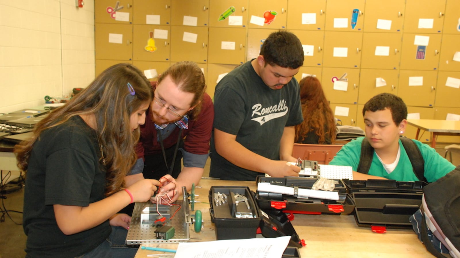 Roncalli Middle School social studies teacher Michael Lonsberry, center left, works with students on a robotics project in April. Roncalli is the lowest performing middle school in the state. As part of the district's turnaround effort, it is rolling out a science, technology, engineering, and math program.