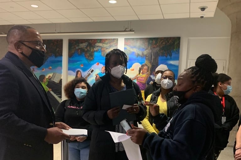 Safety official talks to parents in a tight hallway.