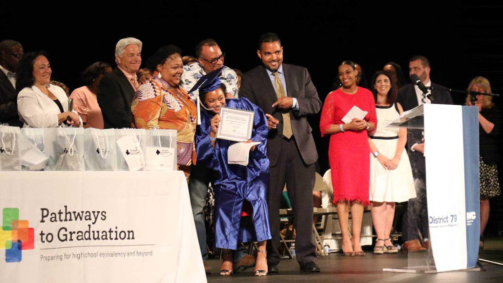 Jasmine Byrd receives an award for excellence after giving a speech to her fellow graduates.
