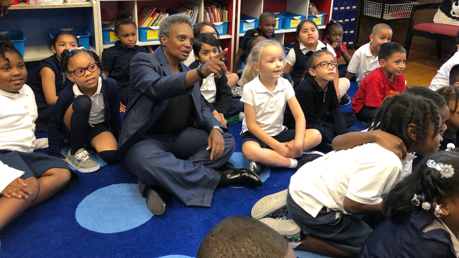 Chicago Mayor Lori Lightfoot sits with students on the first day of school at Salazar Elementary Bilingual Center. If teachers walk out this fall, some 361,000 Chicago students would be affected.