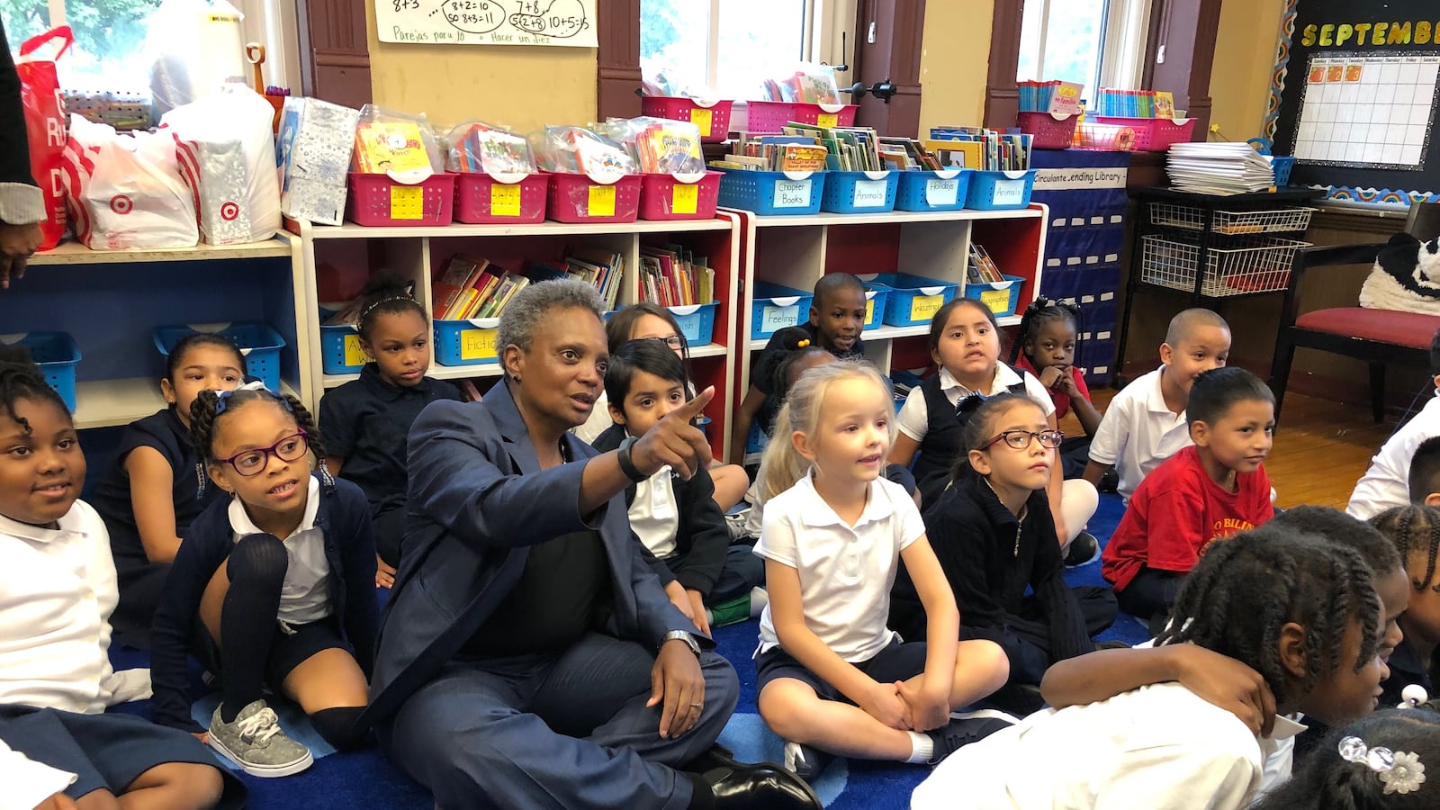 Chicago Mayor Lori Lightfoot sits with students on the first day of school at Salazar Elementary Bilingual Center. If teachers walk out this fall, some 361,000 Chicago students would be affected.