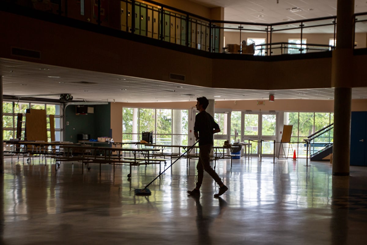A silhouette of a man pushing a broom.