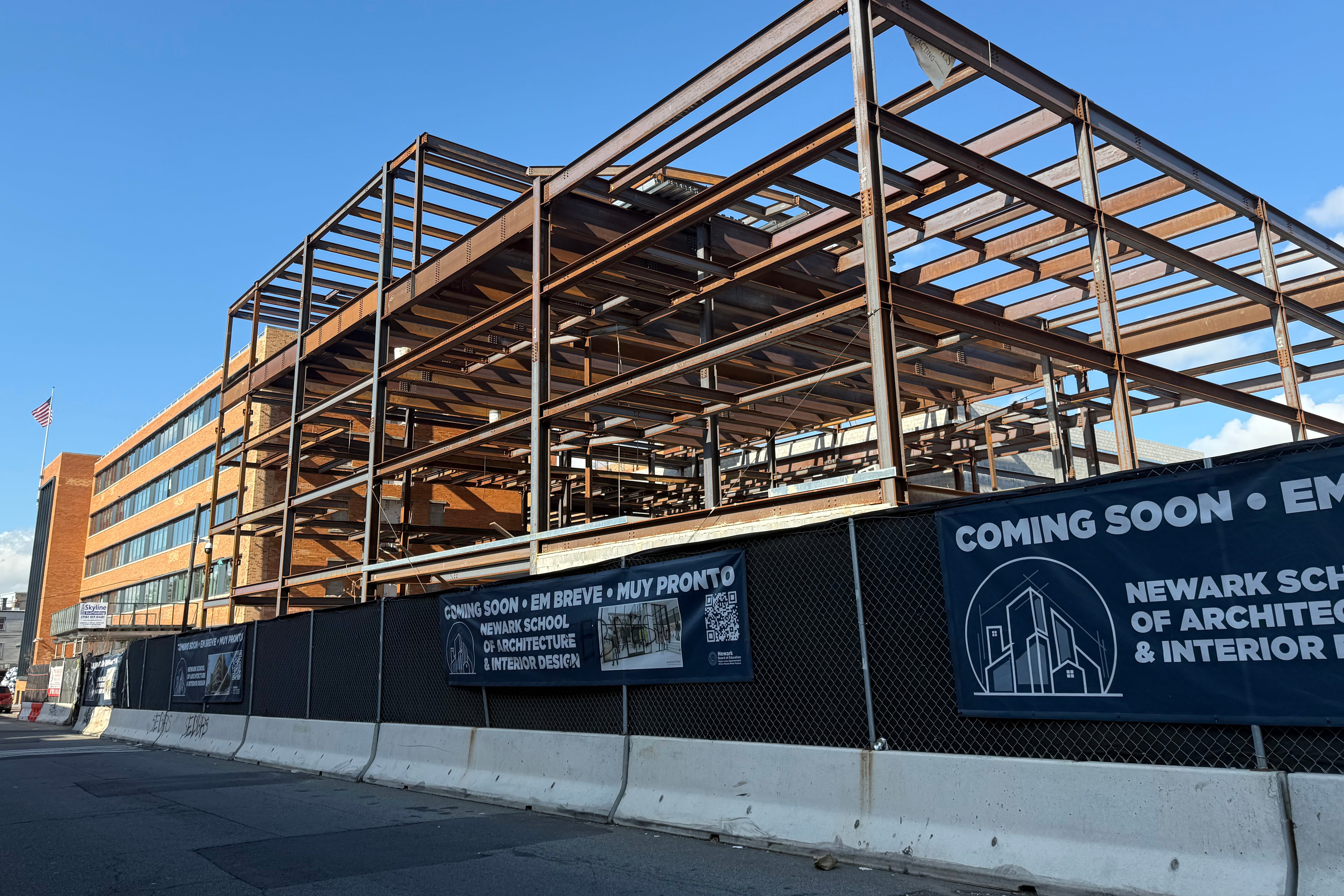 A photograph of a large building under construction against a blue sky background.
