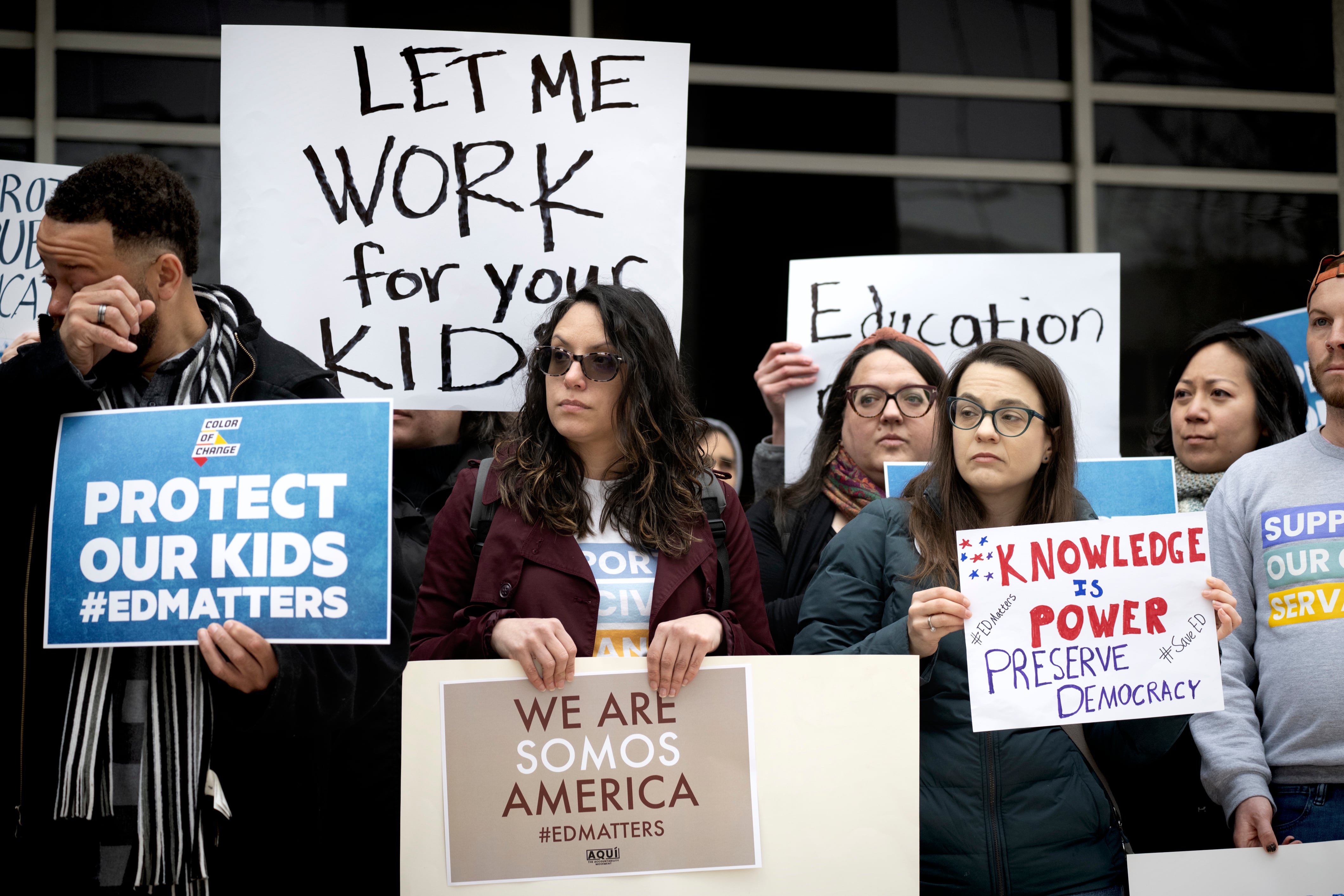 People stand in a group holding signs.