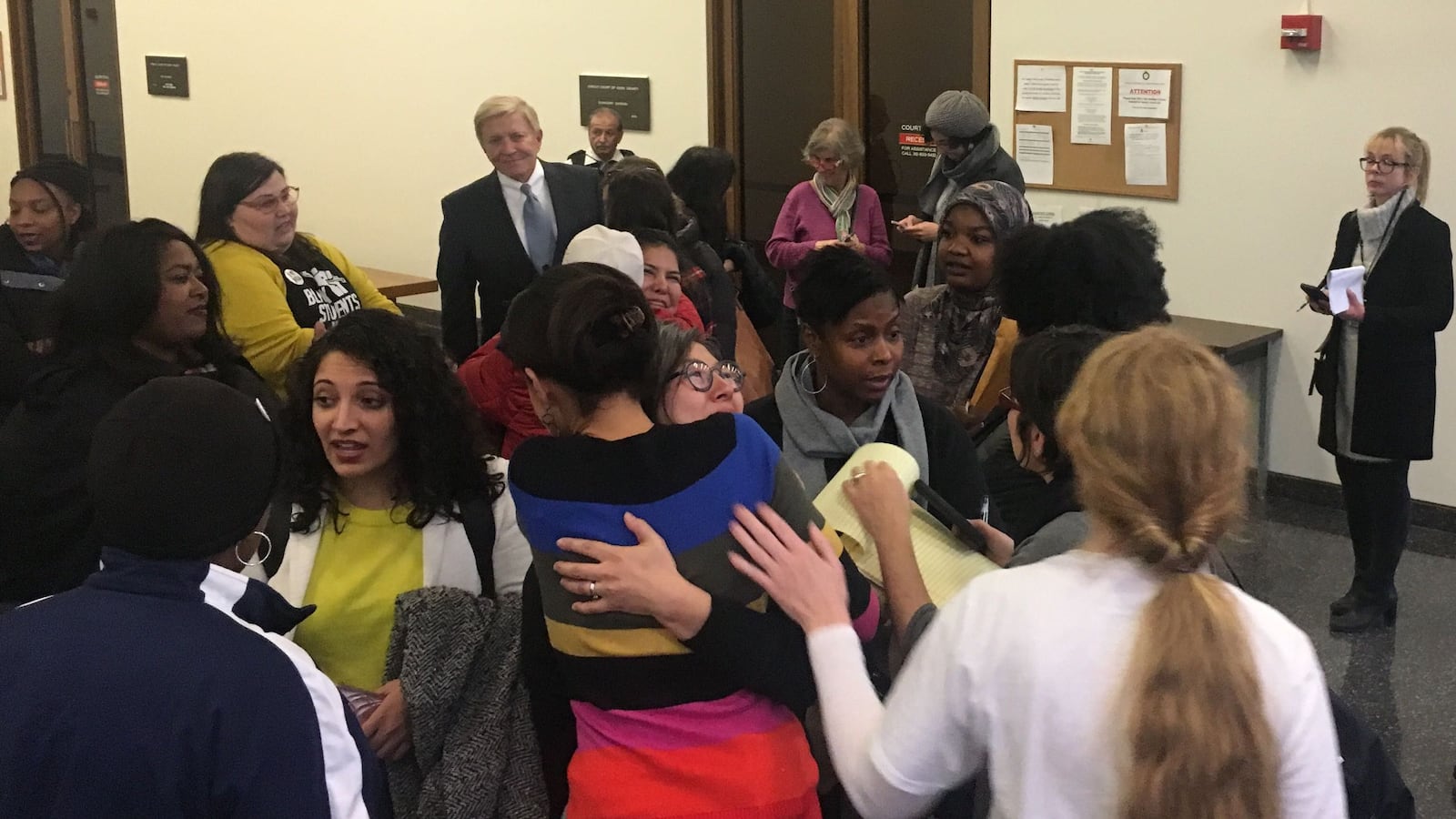 Supporters of NTA celebrate in the hallway outside the courtroom on Monday.