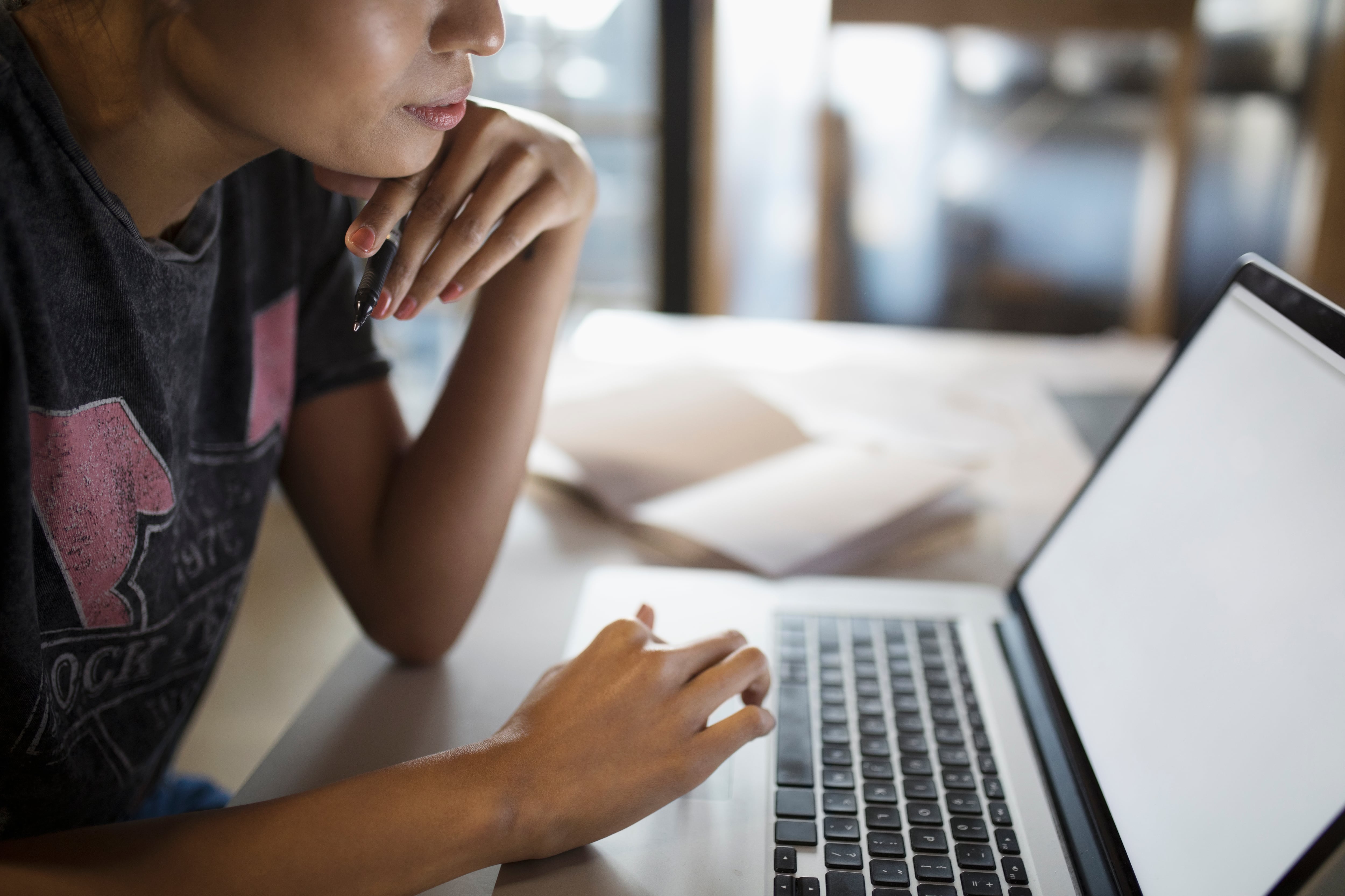 A photo of a student on their laptop at home.
