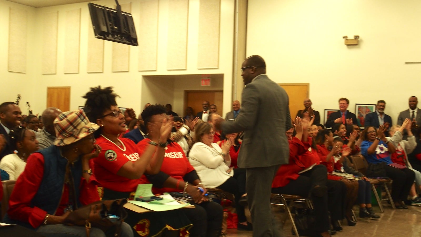 Meeting attendees applaud after Kirby High principal Steevon Hunter voices strong support to make interim superintendent Joris Ray permanent.