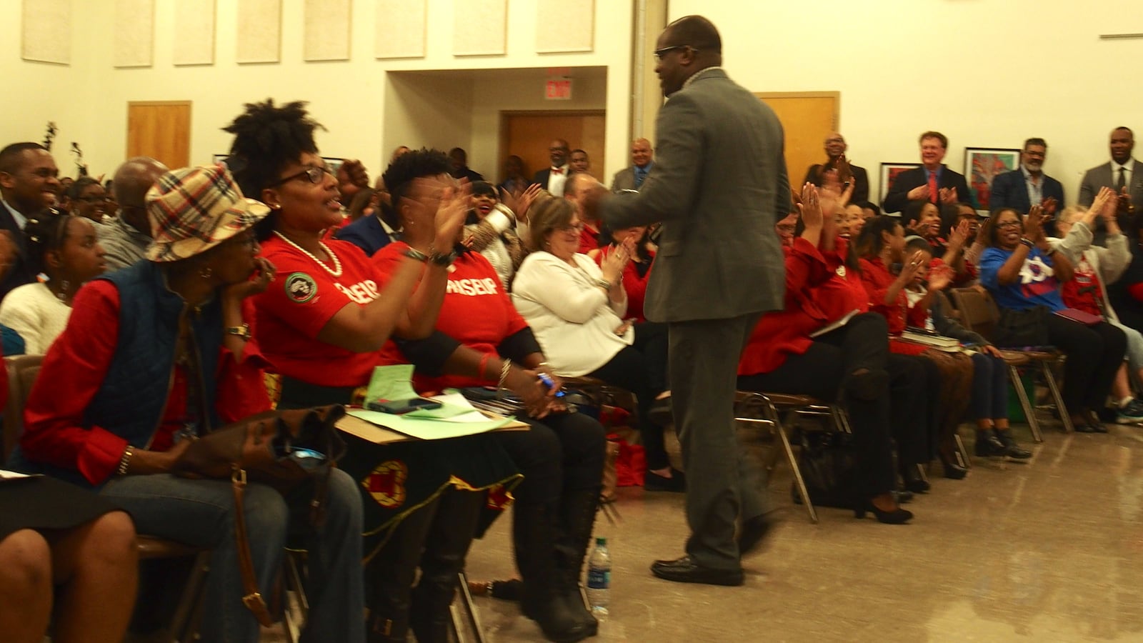 Meeting attendees applaud after Kirby High principal Steevon Hunter voices strong support to make interim superintendent Joris Ray permanent.