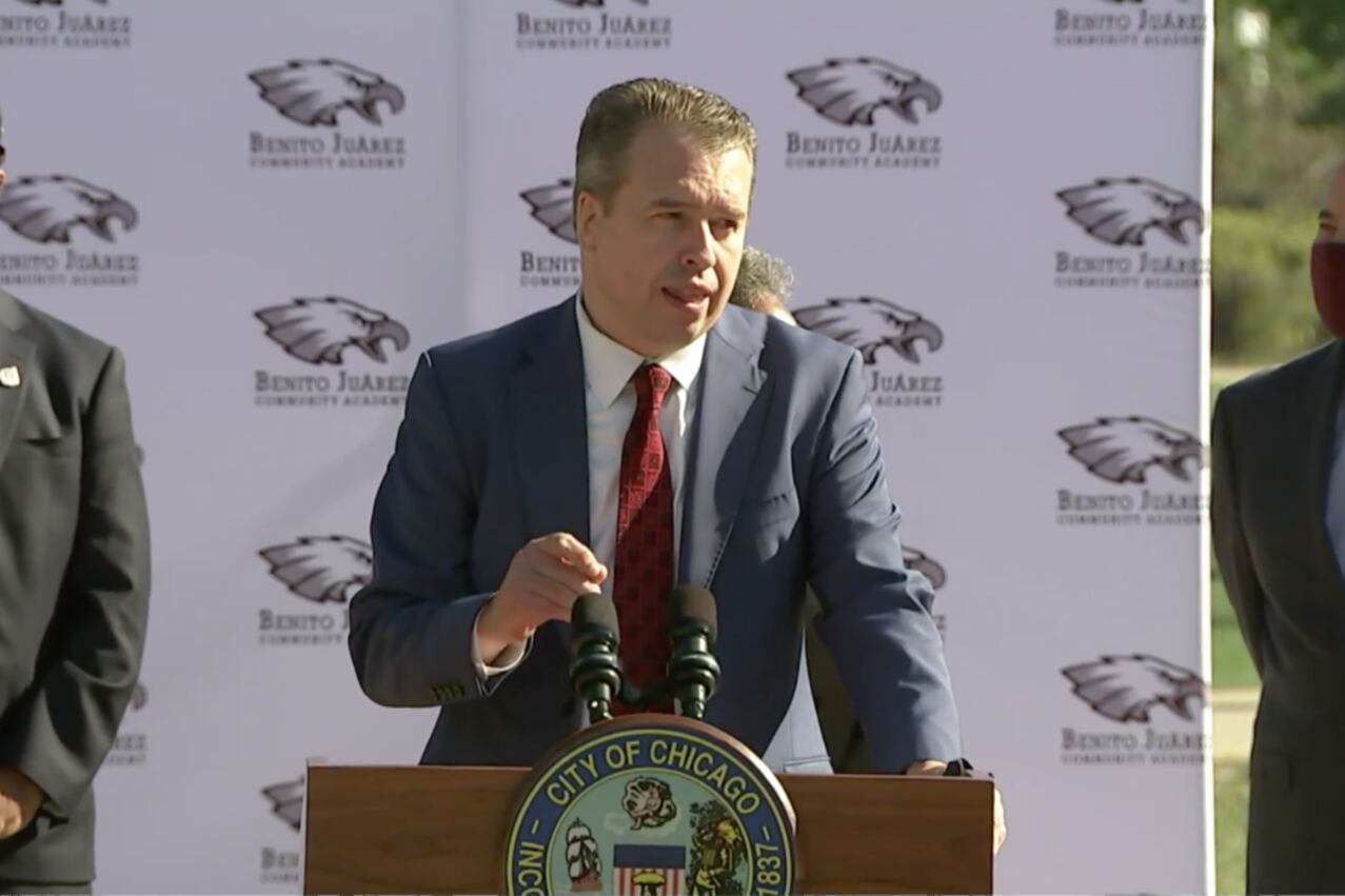Chicago’s new schools chief, Pedro Martinez, delivers an introductory address at podium flanked by district officials.