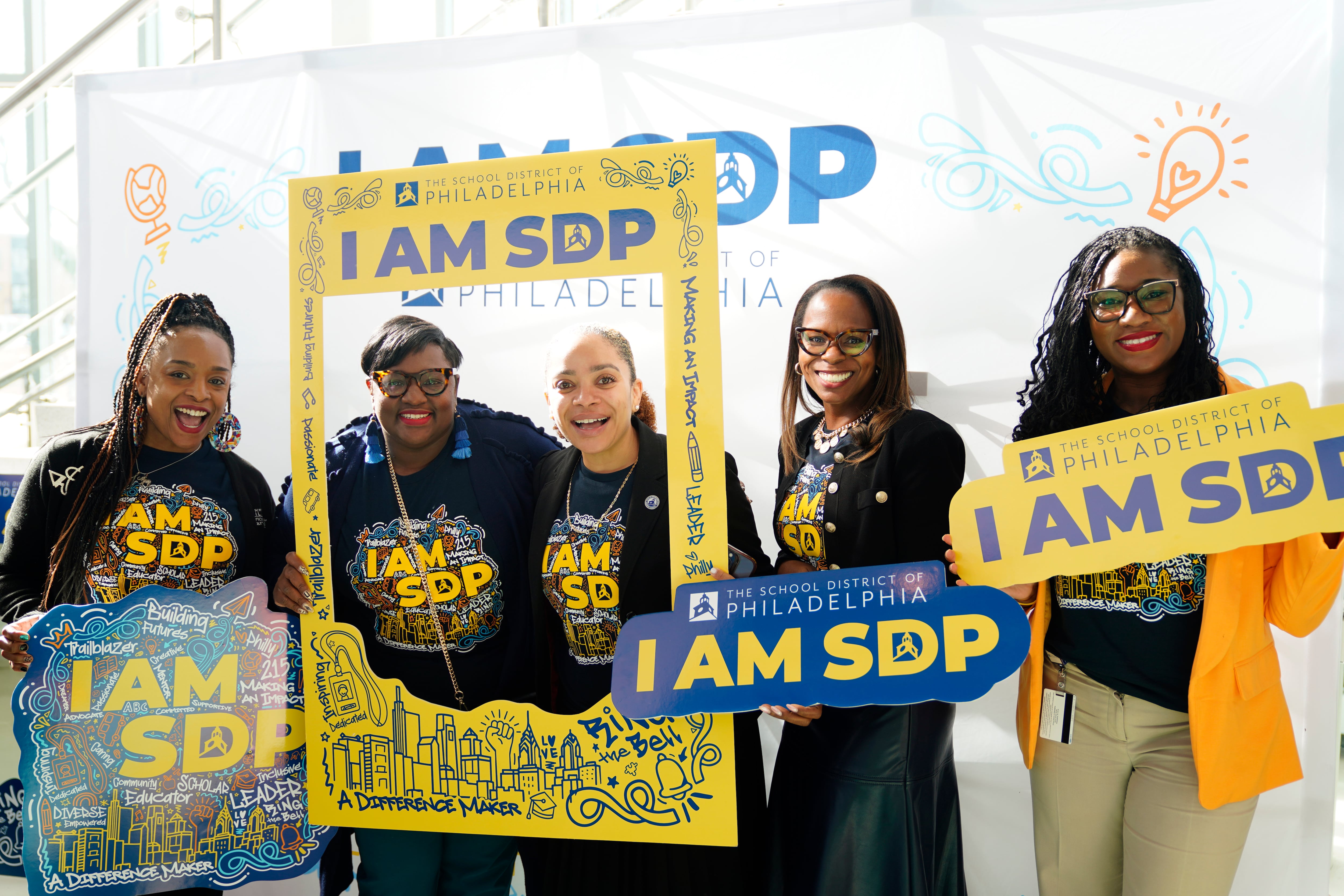 A photograph of five women standing next to each other outside.