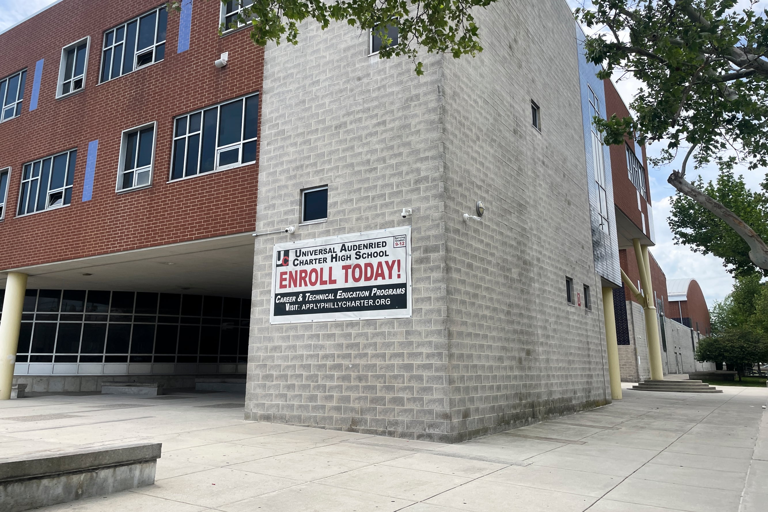A brown stone building with a banner that reads "Enroll Today."