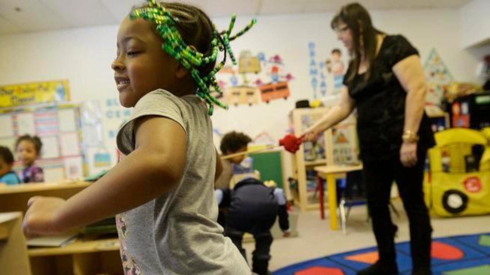Zoe Johnson, 4, dances after walking through the limbo line in her Little Discoverers classroom at HOPE Center.
