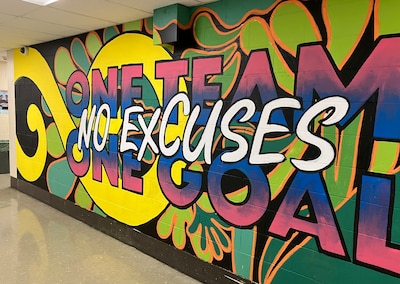 A colorful mural on a wall inside of a school.