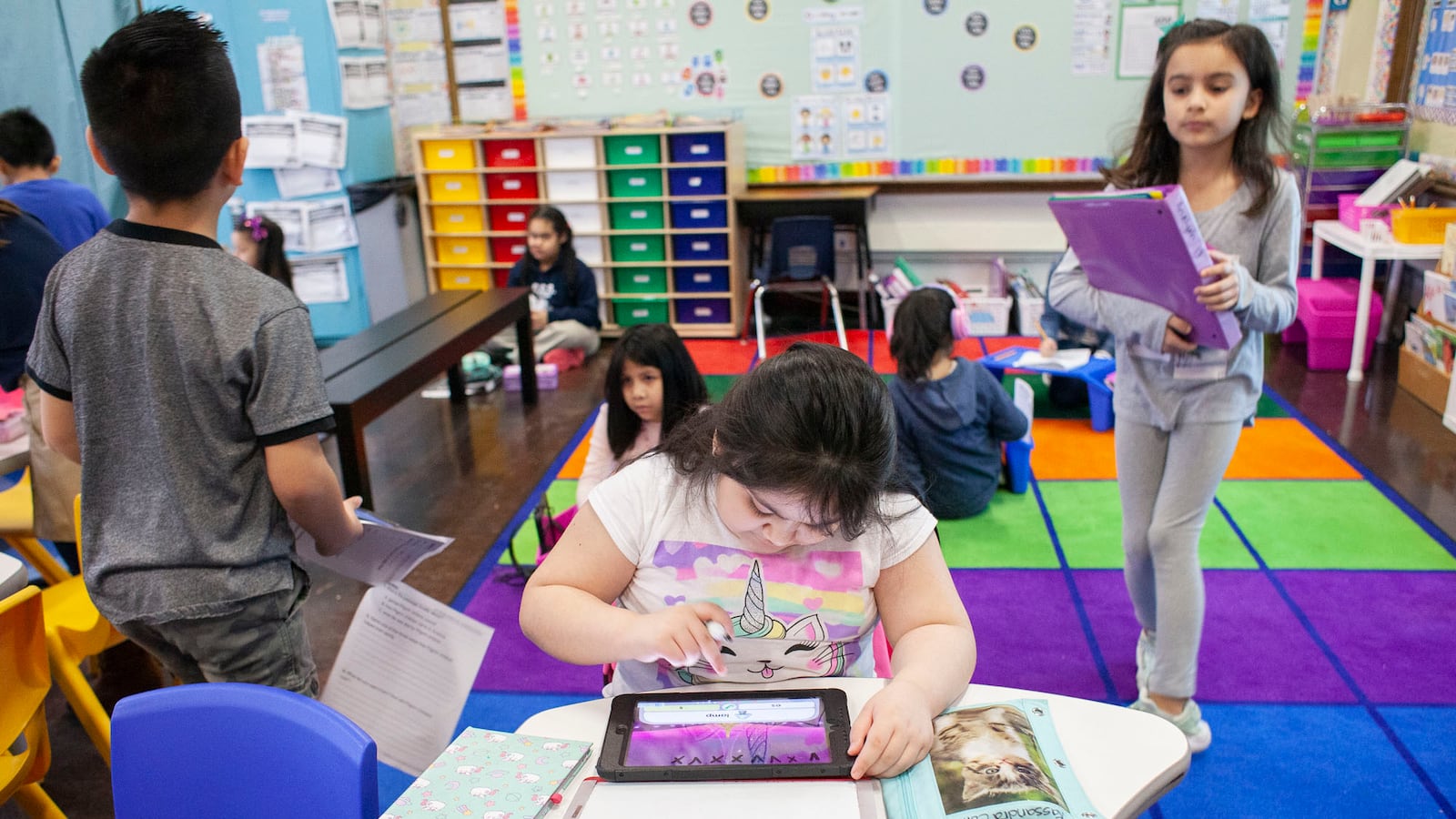 Kassandra C., center, concentrates on her iPad lesson while classmates work on independent assignments during class at CICS West Belden, a Chicago charter school. Photo by Stacey Rupolo/Chalkbeat NOTE: Last names not given by school