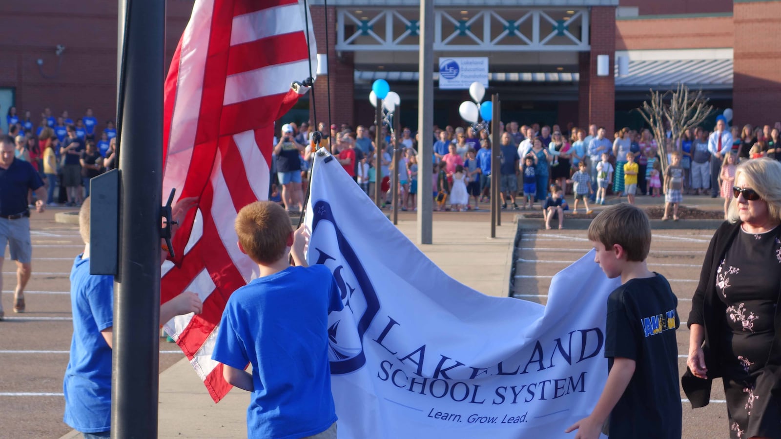 Students raise the Lakeland banner at its ribbon cutting ceremony.