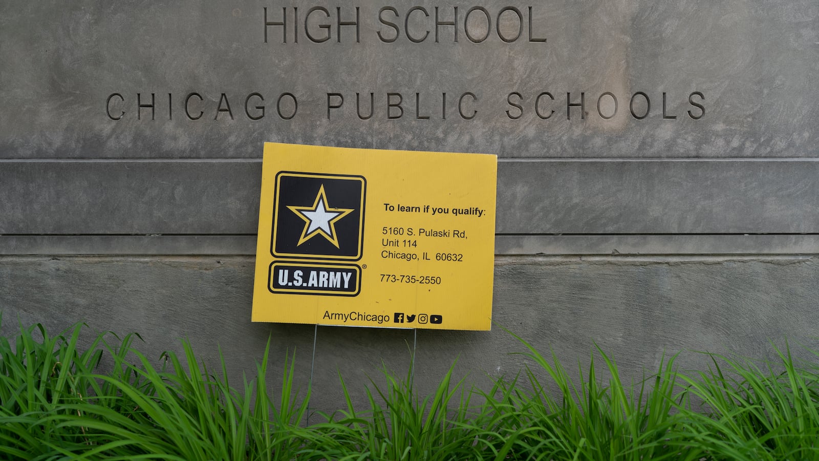 A yellow U.S. Army recruiting sign rests on the entrance sign from Dr. Martin Luther King Jr. College Preparatory High School in Chicago, Ill.